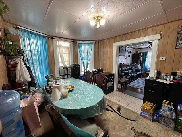 dining room featuring tile patterned floors, cooling unit, and wood walls