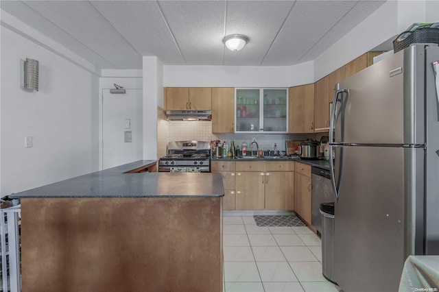 kitchen featuring sink, a textured ceiling, decorative backsplash, light tile patterned floors, and appliances with stainless steel finishes