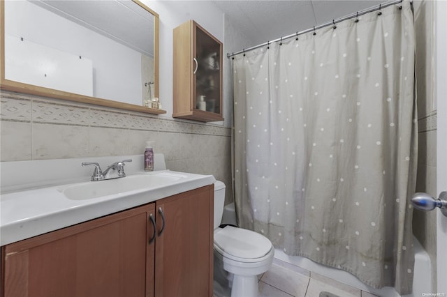 bathroom with vanity, tile patterned floors, toilet, tile walls, and a textured ceiling