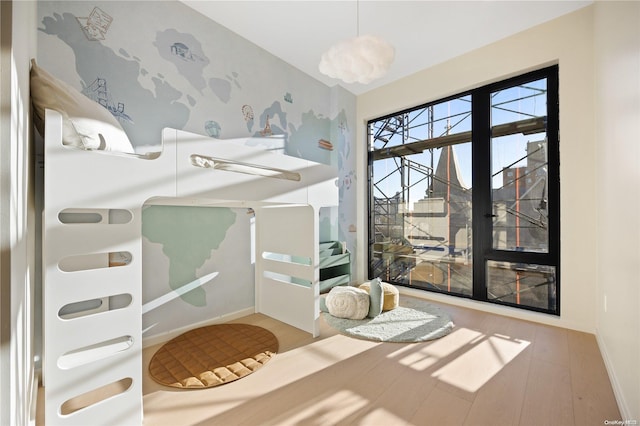 31-16 21st St Unit Ph2C, Astoria, NY 11106 - bedroom with wood finished floors, baseboards, and wallpapered walls