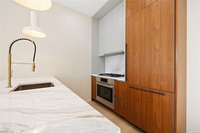 31-16 21st St Unit Ph2C, Astoria, NY 11106 - kitchen featuring stainless steel oven, a sink, modern cabinets, and light stone countertops