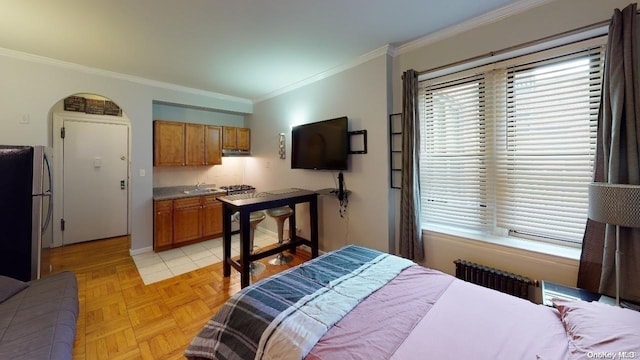 bedroom featuring light parquet floors, sink, crown molding, stainless steel fridge, and radiator heating unit