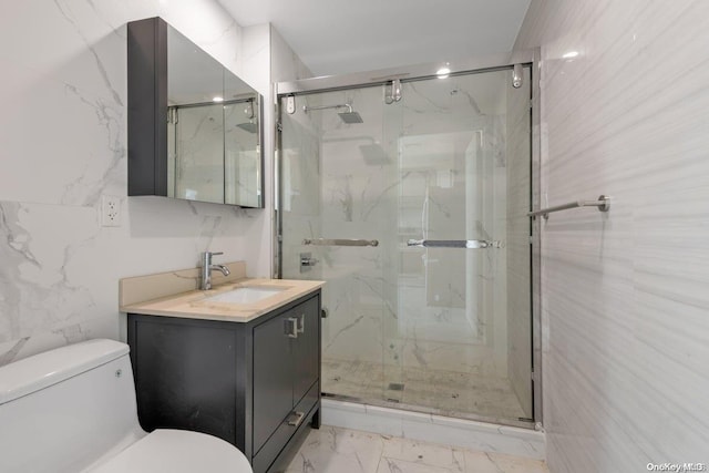 bathroom with vanity, toilet, a shower with door, and tile walls