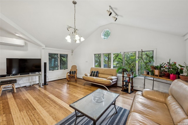 living room featuring high vaulted ceiling, track lighting, an inviting chandelier, light wood-type flooring, and a wall unit AC