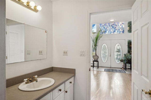 bathroom with vanity, wood-type flooring, and french doors