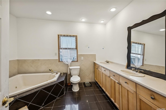 bathroom with vanity, tiled bath, toilet, and plenty of natural light