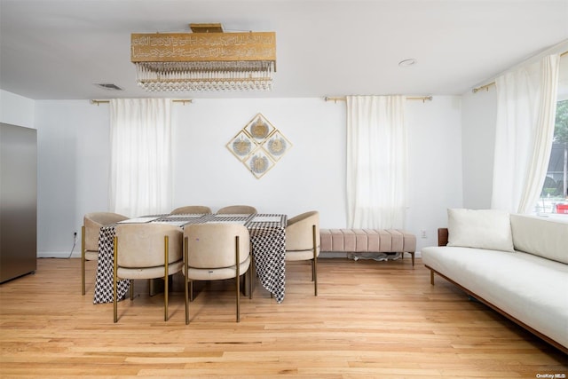 dining area with light hardwood / wood-style floors and plenty of natural light