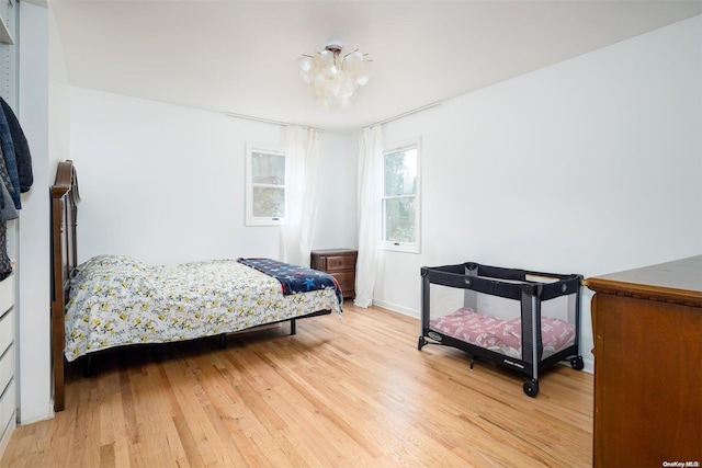 bedroom featuring hardwood / wood-style flooring and an inviting chandelier