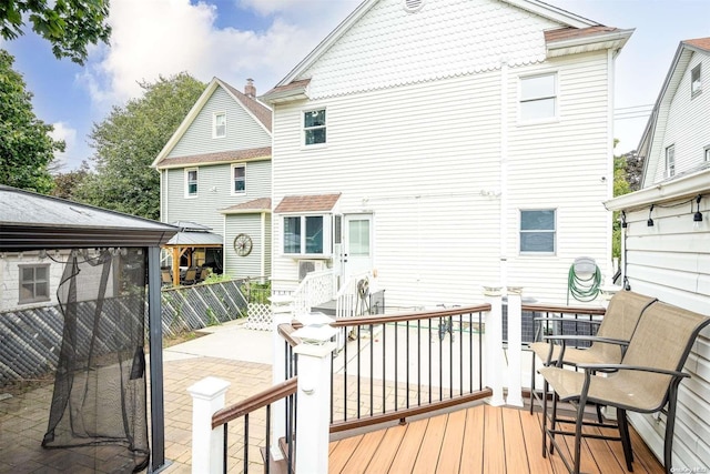 back of property featuring a deck, a patio area, and a gazebo