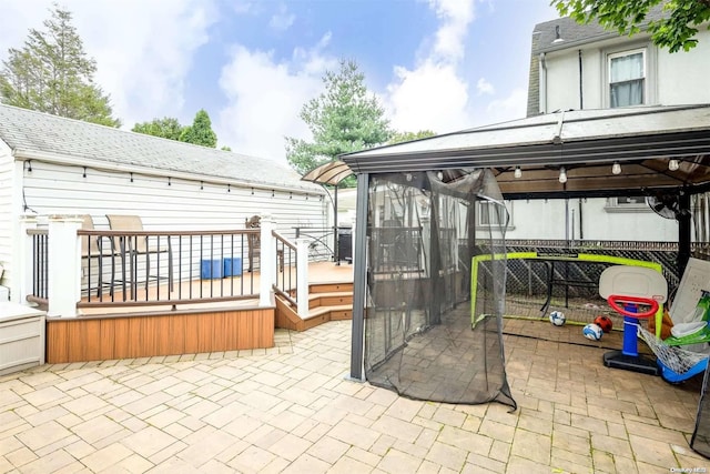 view of patio / terrace with a wooden deck, a sunroom, and a jacuzzi