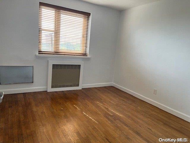 unfurnished room featuring dark hardwood / wood-style flooring