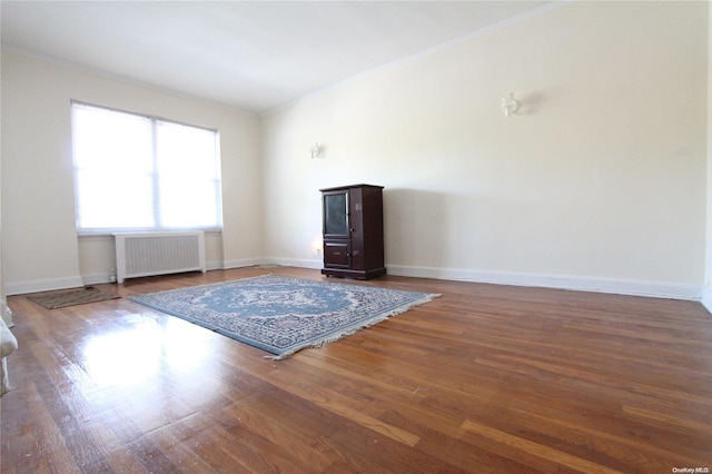 unfurnished living room featuring dark hardwood / wood-style floors and radiator