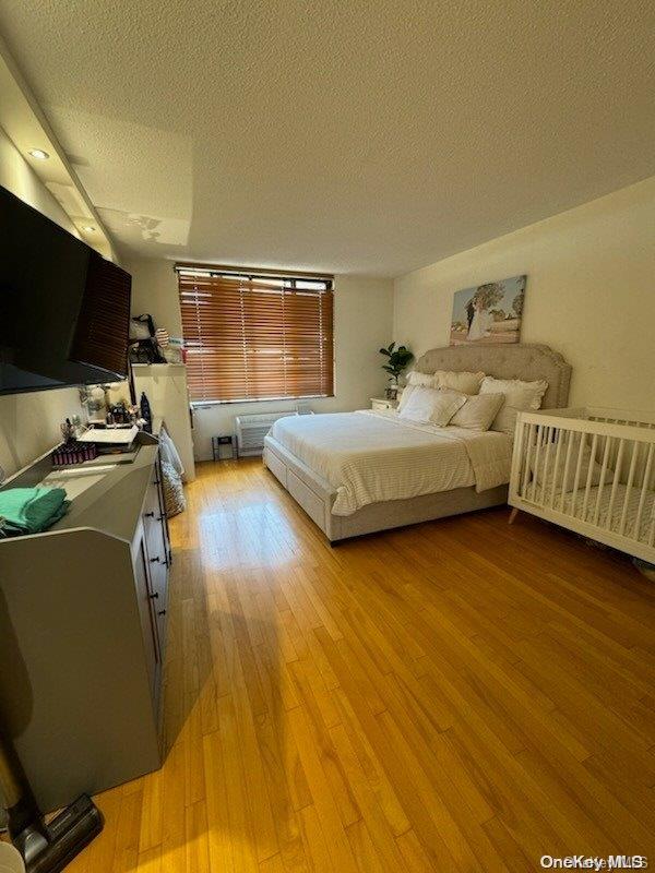 bedroom featuring a textured ceiling and light hardwood / wood-style floors