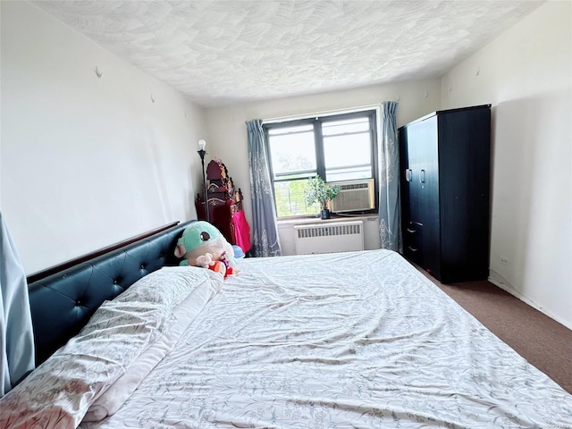 carpeted bedroom with radiator, cooling unit, and a textured ceiling