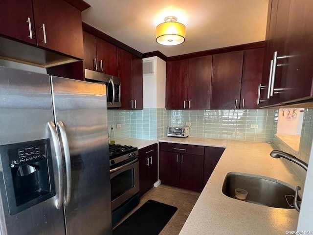 kitchen with appliances with stainless steel finishes, tasteful backsplash, and sink