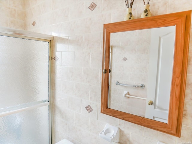 bathroom featuring an enclosed shower and tile walls