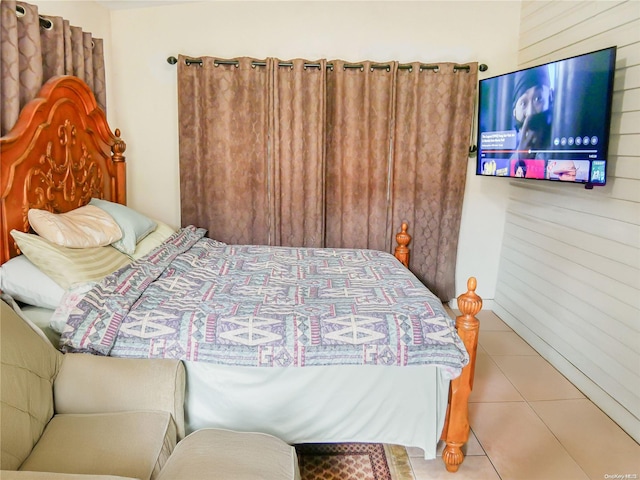 tiled bedroom featuring wood walls