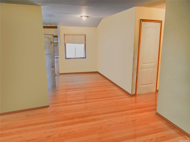 hall featuring light hardwood / wood-style floors and lofted ceiling