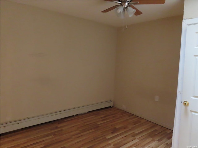 spare room featuring hardwood / wood-style flooring, ceiling fan, and baseboard heating