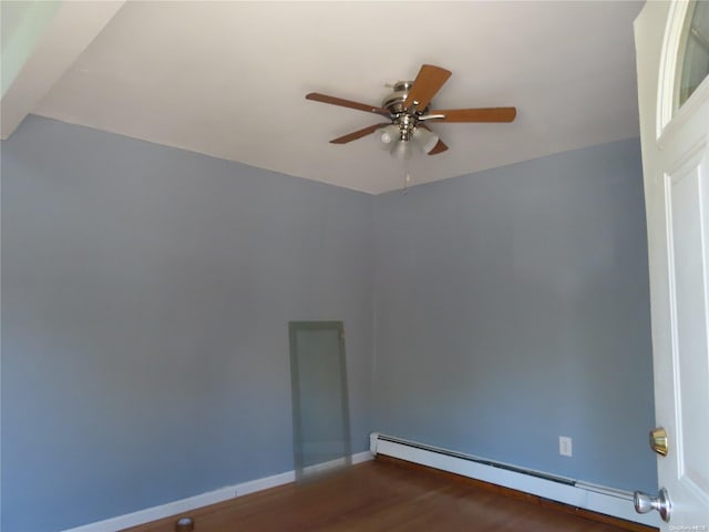 spare room with ceiling fan, wood-type flooring, and a baseboard heating unit