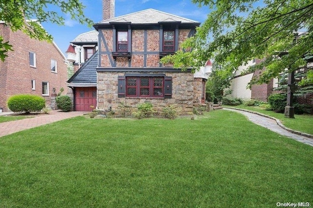 29-37 168th St, Flushing, NY 11358 - view of front of property with stone siding, a front lawn, a chimney, and driveway