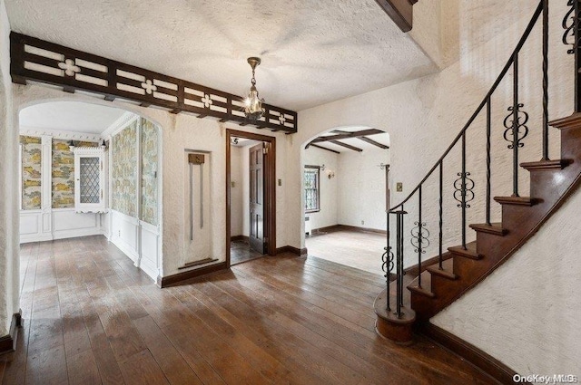 foyer featuring a textured ceiling and dark hardwood / wood-style floors