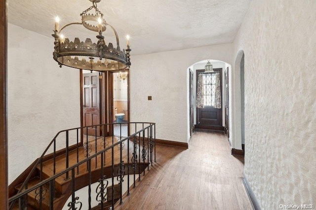 hall featuring wood-type flooring and a textured ceiling