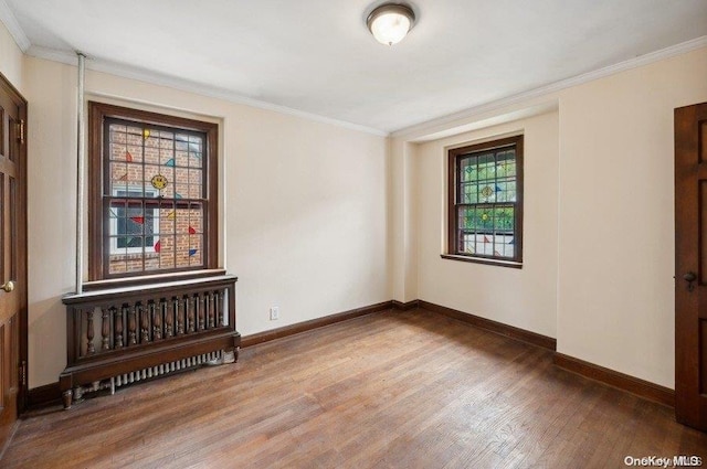 unfurnished room with wood-type flooring and ornamental molding