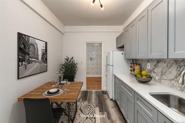 kitchen featuring gray cabinetry, dark wood-type flooring, sink, decorative backsplash, and white fridge