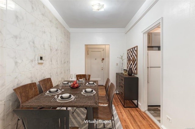 dining room with wood-type flooring and tile walls