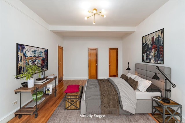 bedroom featuring hardwood / wood-style floors and a notable chandelier