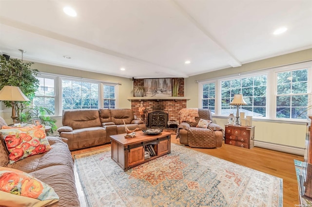 living room with a wealth of natural light, beamed ceiling, light hardwood / wood-style floors, and a baseboard radiator