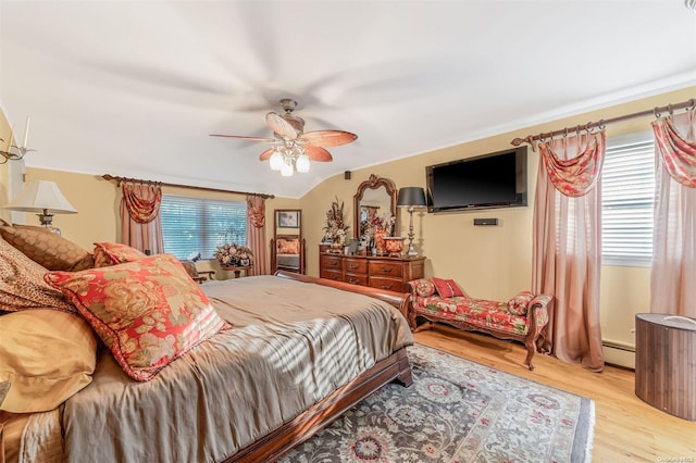 bedroom with lofted ceiling, light hardwood / wood-style floors, ceiling fan, and a baseboard heating unit