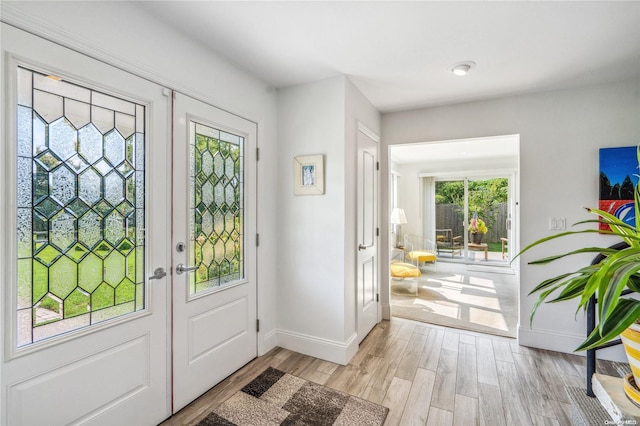 entryway featuring french doors, light hardwood / wood-style flooring, and a healthy amount of sunlight