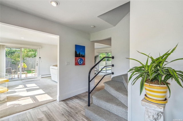 stairway featuring a baseboard radiator and hardwood / wood-style flooring