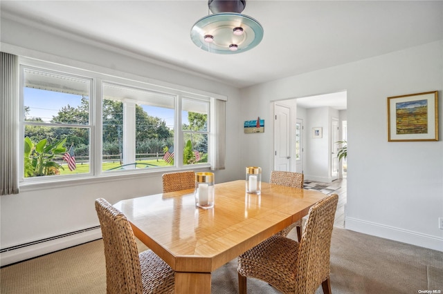 dining space featuring light colored carpet and baseboard heating