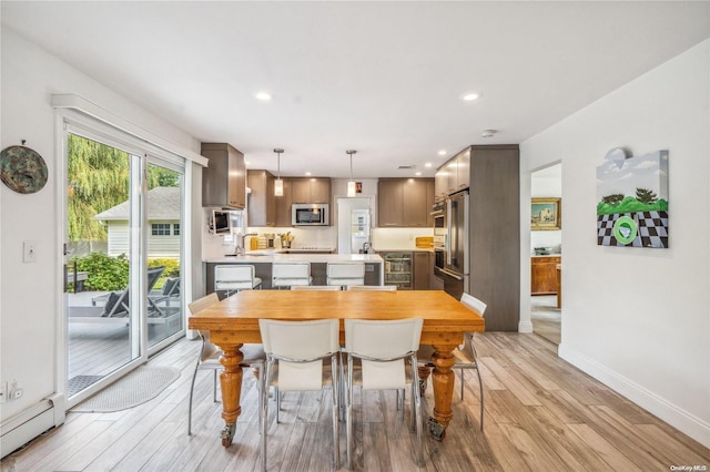 dining room featuring wine cooler, light hardwood / wood-style floors, and a baseboard radiator