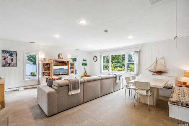 living room featuring baseboard heating, a wealth of natural light, and light carpet