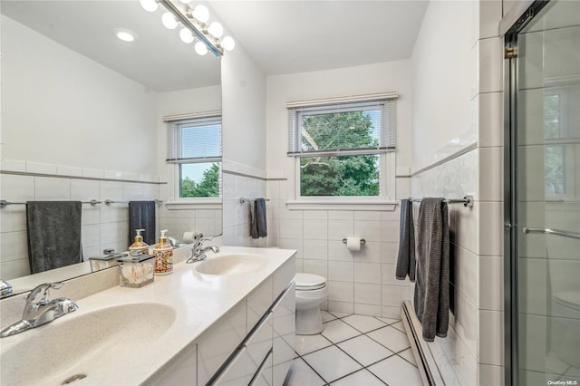 bathroom featuring vanity, a baseboard heating unit, tile patterned flooring, toilet, and tile walls