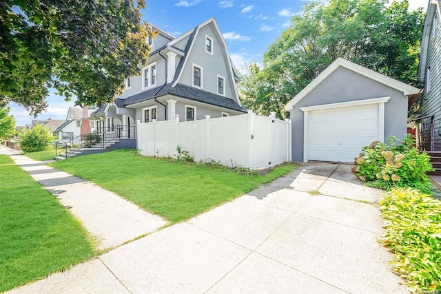 view of front of home with an outbuilding, a garage, and a front yard