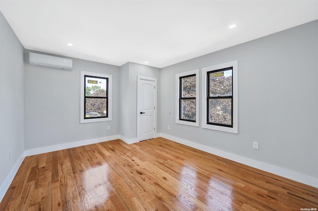 empty room featuring light hardwood / wood-style flooring and a wall mounted AC