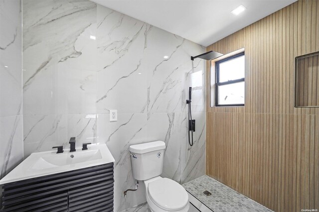 bathroom with vanity, toilet, and tiled shower