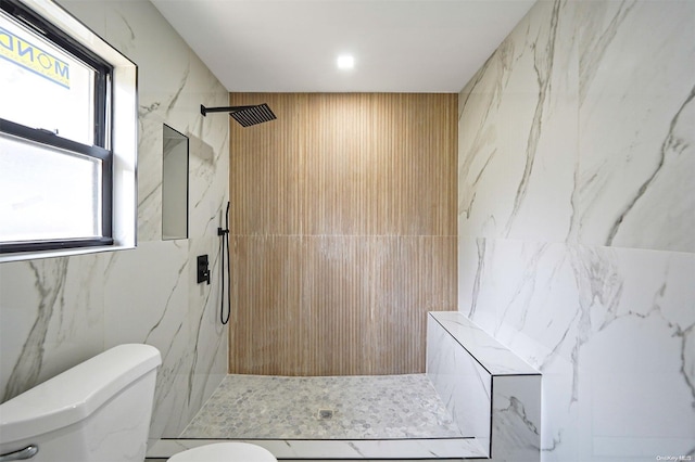 bathroom featuring tiled shower and toilet