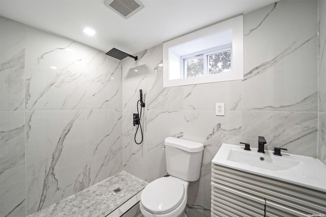 bathroom featuring vanity, tiled shower, and toilet