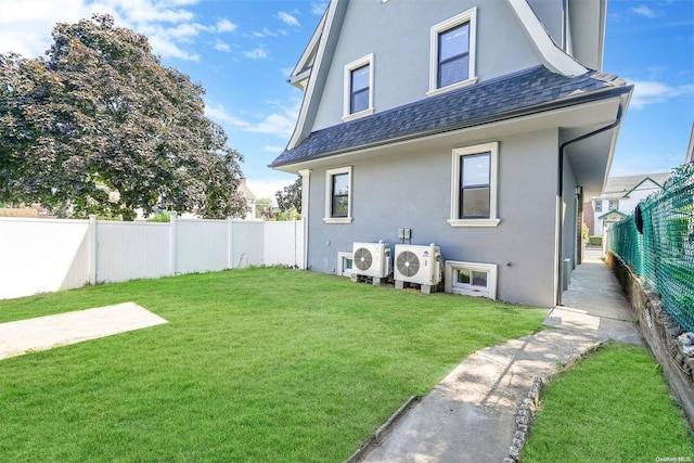 back of house featuring a lawn and ac unit