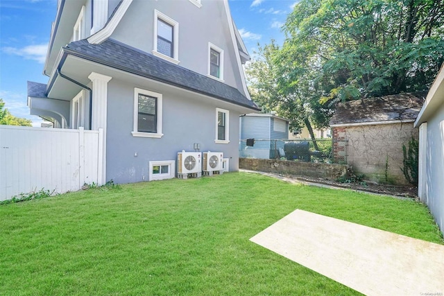 rear view of property with a yard and ac unit