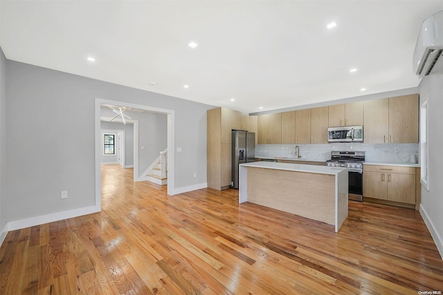 kitchen featuring sink, appliances with stainless steel finishes, decorative backsplash, an AC wall unit, and light wood-type flooring