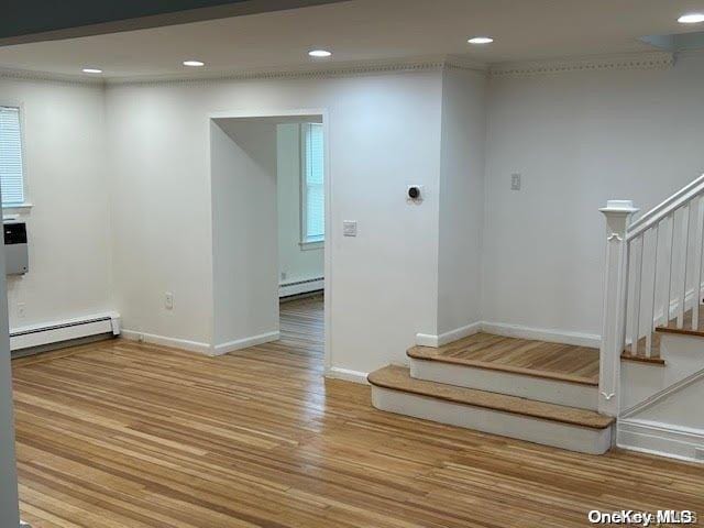 interior space with wood-type flooring and a baseboard radiator