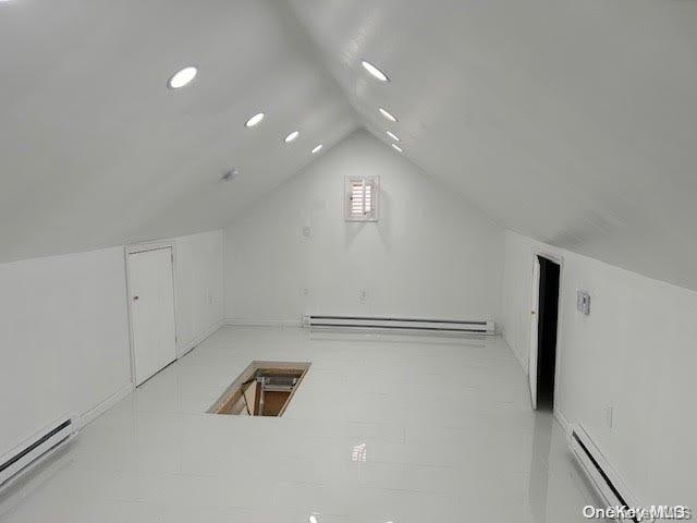 bonus room with baseboard heating and lofted ceiling