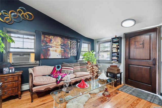 living room featuring lofted ceiling, light wood-type flooring, cooling unit, and a baseboard heating unit